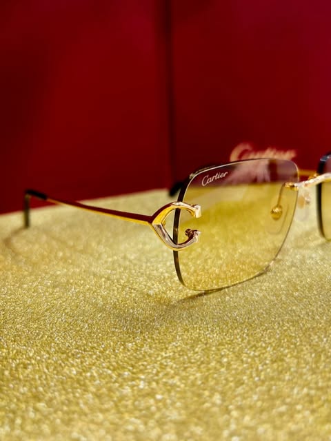 Rimless Cartier glasses with the gold C décor bridge, on a gold ground