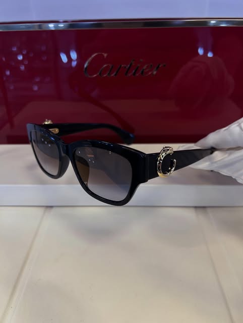 Black Cartier sunglasses with the gold Panthère ring detail
