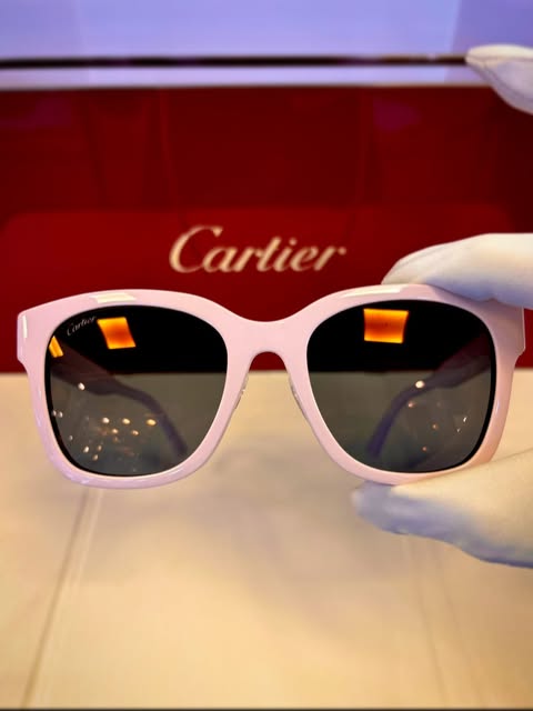 Pale pink Cartier sunglasses presented with the white glove