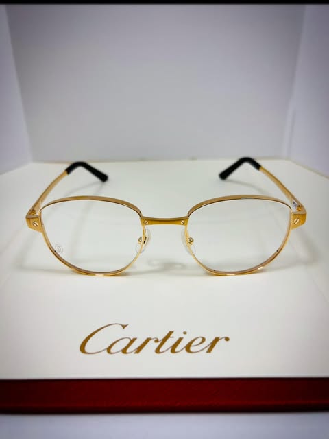 Round gold Cartier frames on a Cartier presentation box