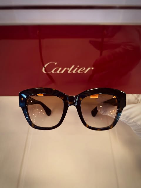 Tortoiseshell sunglasses photographed in the boutique against a Cartier display