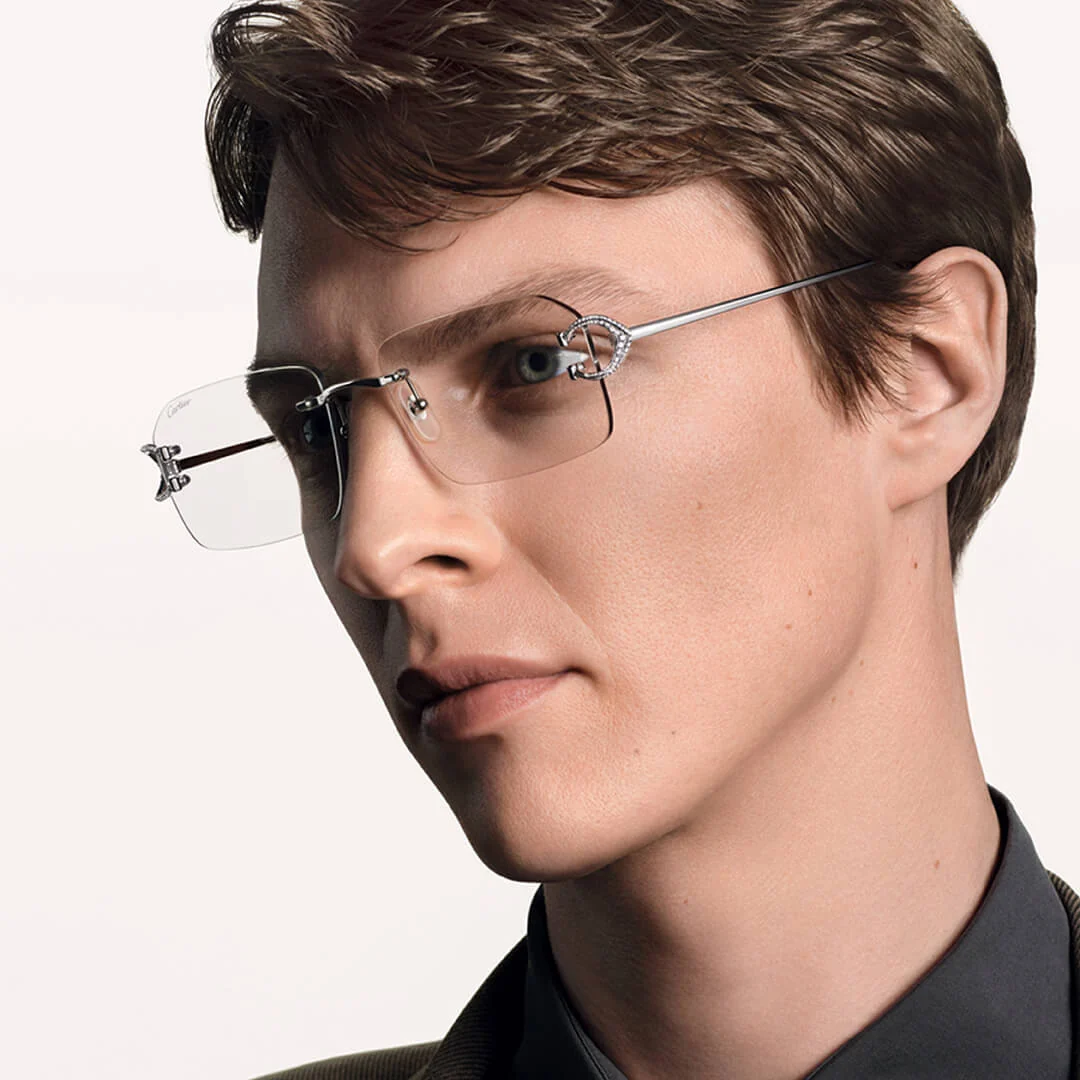 A model wearing rimless Cartier eyeglasses with the diamond-set C décor temple